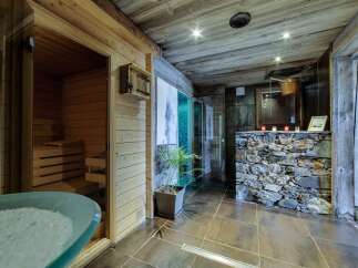 Indulge in ultimate relaxation in this luxurious spa featuring a traditional wooden sauna and a modern steam shower.