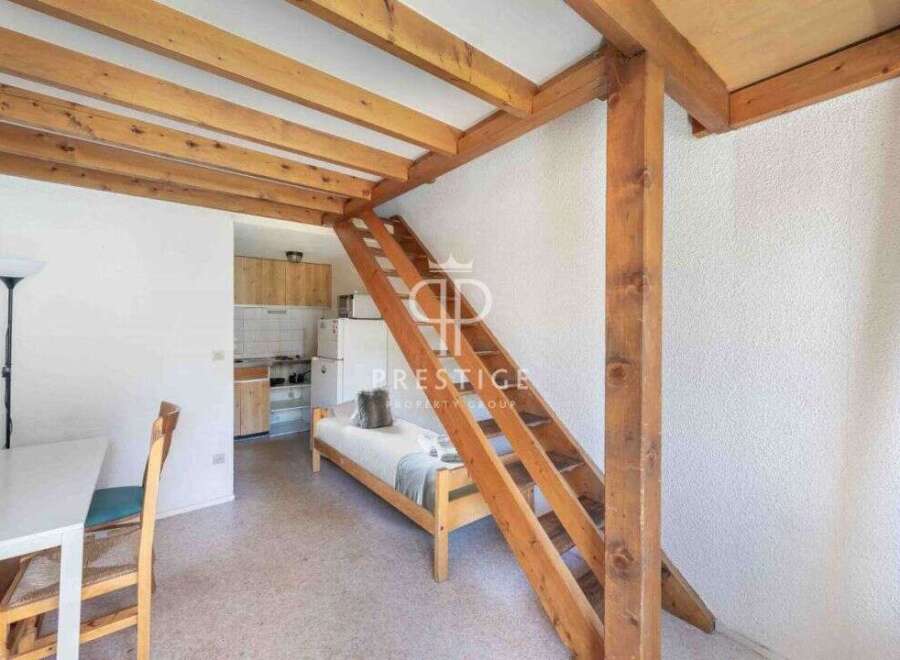 Discover this charming property featuring a unique loft design with wooden beams and a cozy sleeping area.