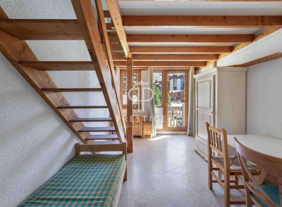 Discover a charming property featuring a unique wooden staircase leading to a cozy loft space.
