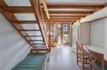 Discover a charming property featuring a unique wooden staircase leading to a cozy loft space.
