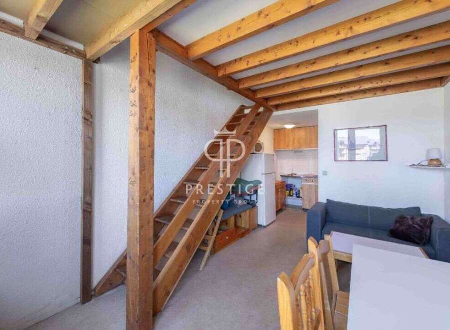 Discover this charming property featuring a unique loft design with exposed wooden beams and a staircase.