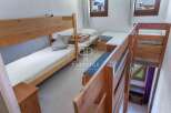 Discover a cozy bedroom with a unique layout, featuring a bunk bed and additional sleeping arrangements.