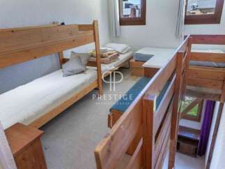 Discover a cozy bedroom with a unique layout, featuring a bunk bed and additional sleeping arrangements.