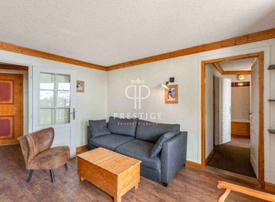 Discover the charm of this inviting living space, featuring a cozy sofa and a rustic wooden coffee table.