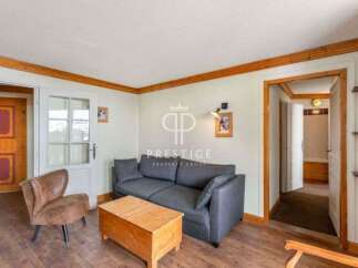 Discover the charm of this inviting living space, featuring a cozy sofa and a rustic wooden coffee table.
