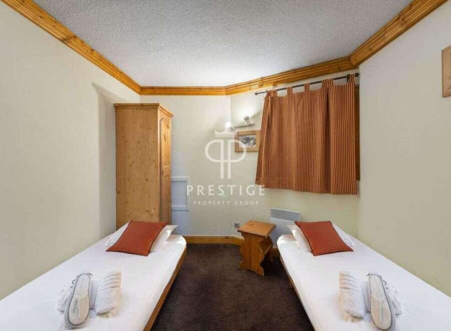 Cozy and inviting bedroom featuring two single beds with fresh linens and plush pillows.