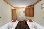 Cozy and inviting bedroom featuring two single beds with fresh linens and plush pillows.