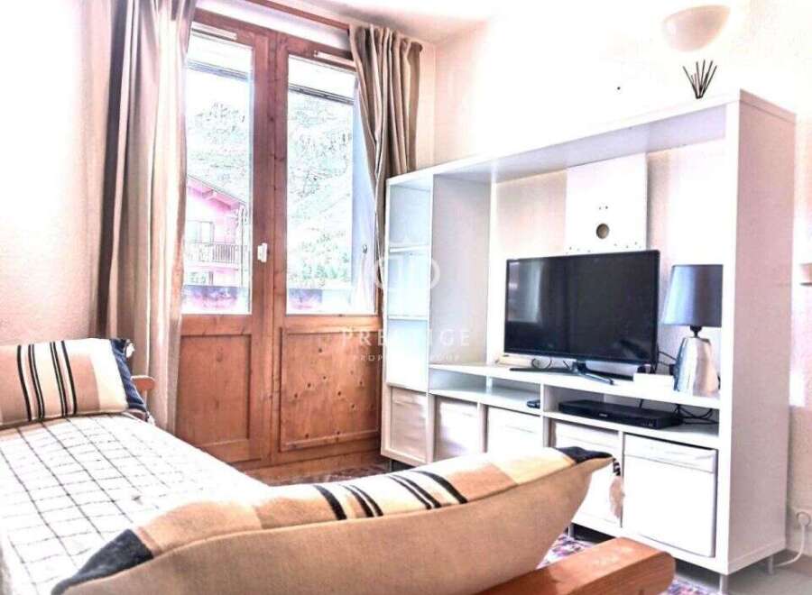 Cozy living space with a comfortable daybed and a modern entertainment unit.