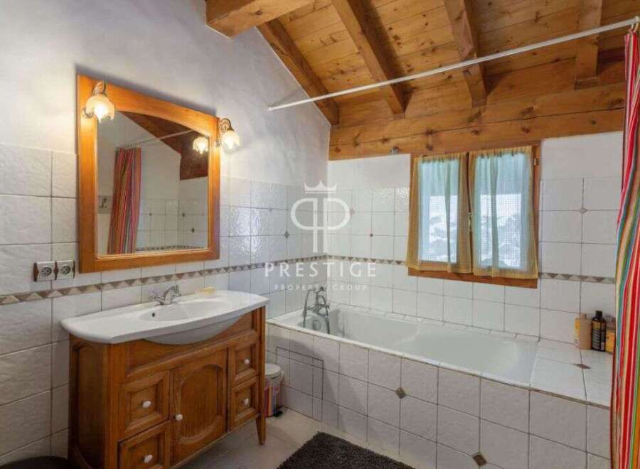 Discover the charm of this bathroom featuring a wooden vanity and a classic white sink.