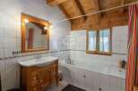 Discover the charm of this bathroom featuring a wooden vanity and a classic white sink.