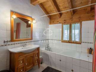 Discover the charm of this bathroom featuring a wooden vanity and a classic white sink.