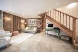 Discover the charm of this stunning property, featuring a cozy living area with wooden paneling and a stylish rug.