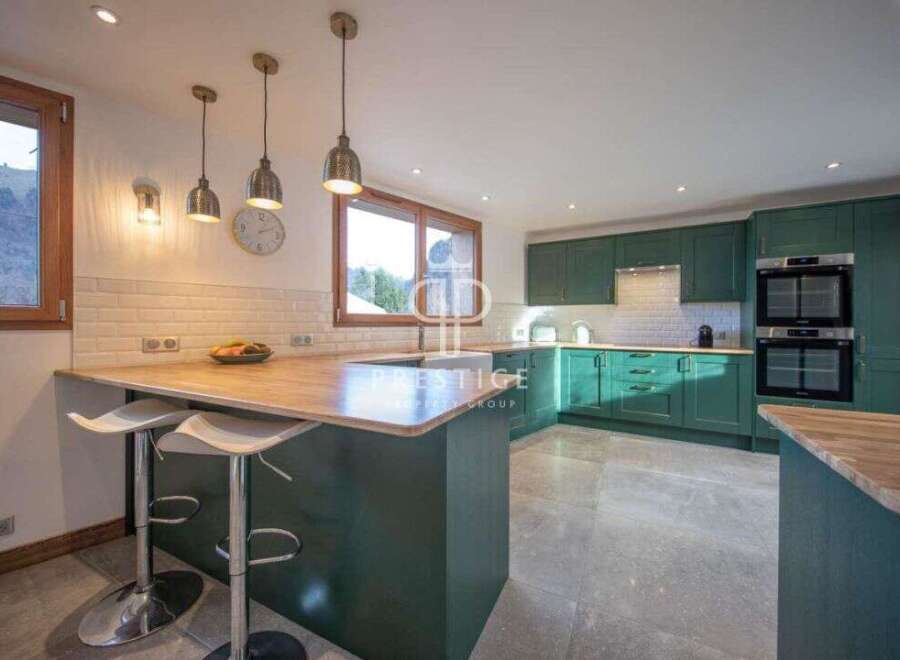 This stunning kitchen boasts a modern design with sleek green cabinetry and a spacious layout.