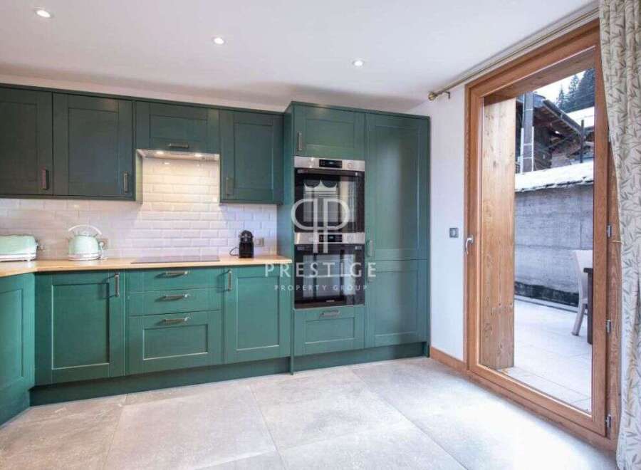 Step into this stunning kitchen, featuring sleek green cabinetry and modern appliances.