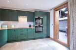 Step into this stunning kitchen, featuring sleek green cabinetry and modern appliances.