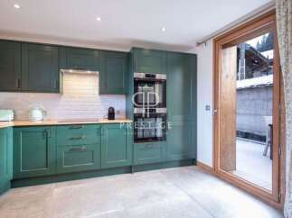 Step into this stunning kitchen, featuring sleek green cabinetry and modern appliances.