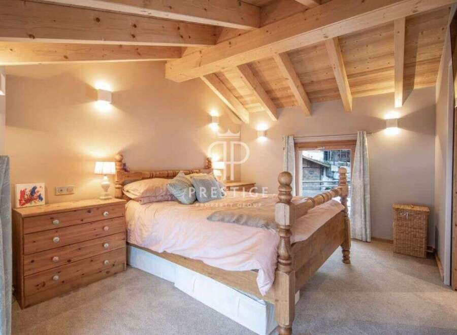 Discover the charm of this cozy bedroom, featuring a rustic wooden bed and a warm, inviting ambiance.