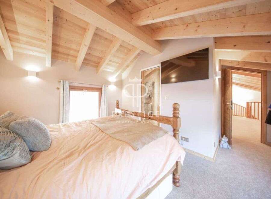 This stunning bedroom boasts a warm and inviting atmosphere with its wooden ceiling and beams.