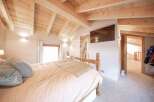 This stunning bedroom boasts a warm and inviting atmosphere with its wooden ceiling and beams.