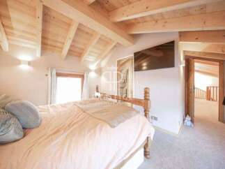 This stunning bedroom boasts a warm and inviting atmosphere with its wooden ceiling and beams.