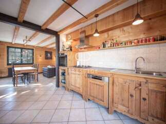 This stunning kitchen boasts rustic charm with its wooden cabinetry and exposed beams.