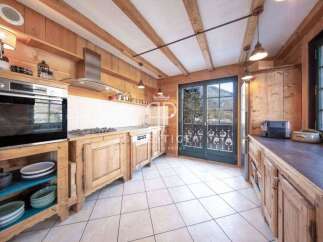 This charming kitchen boasts a rustic design with wooden cabinetry and exposed beams, creating a warm and inviting atmosphere.