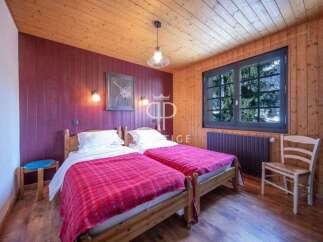This charming bedroom features two twin beds with cozy red blankets, perfect for a comfortable stay.