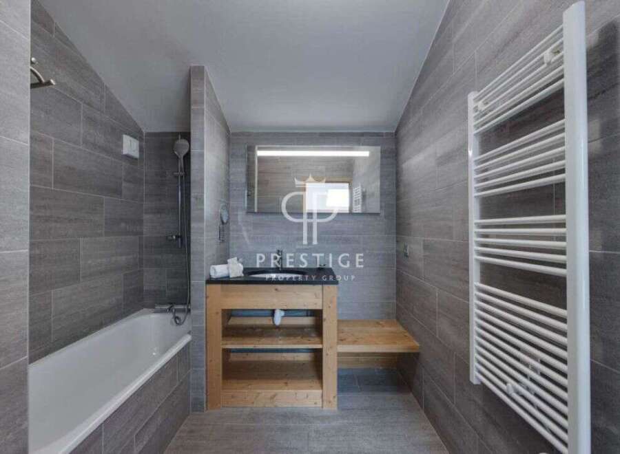 Discover a modern bathroom design featuring sleek gray tiles and a minimalist aesthetic.