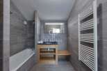 Discover a modern bathroom design featuring sleek gray tiles and a minimalist aesthetic.