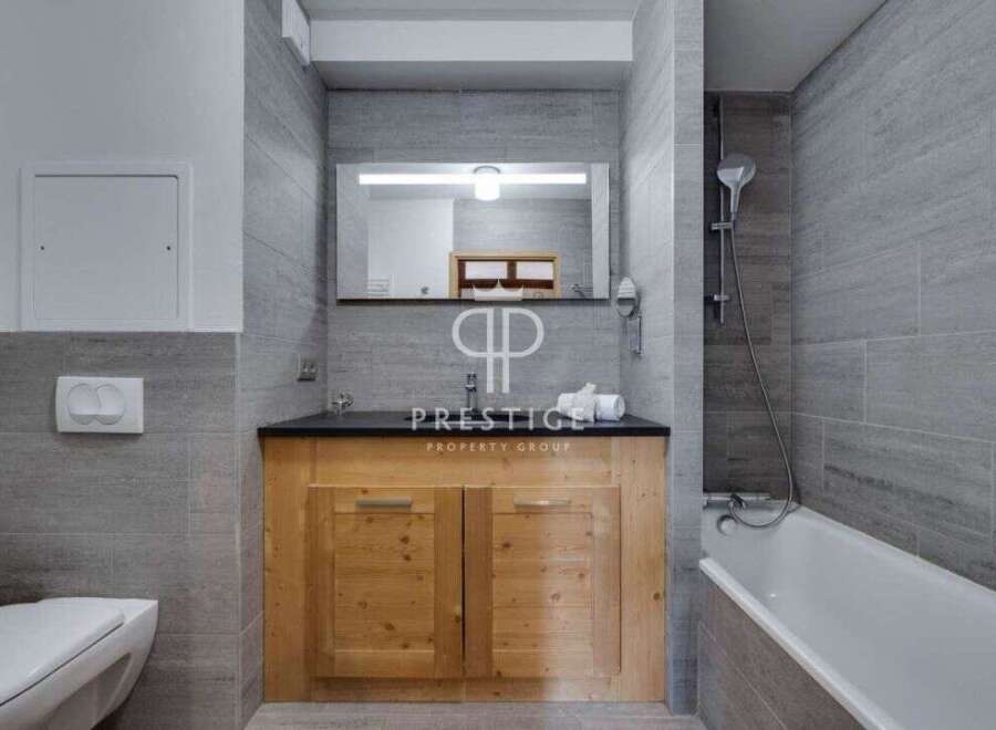 Discover a modern bathroom design featuring a sleek vanity with wooden cabinets and a dark countertop.