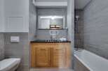 Discover a modern bathroom design featuring a sleek vanity with wooden cabinets and a dark countertop.