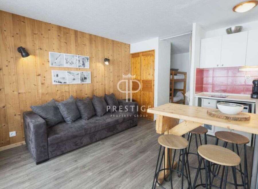 Cozy apartment with a rustic charm, featuring wooden paneling and a comfortable sofa.