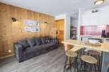 Cozy apartment with a rustic charm, featuring wooden paneling and a comfortable sofa.
