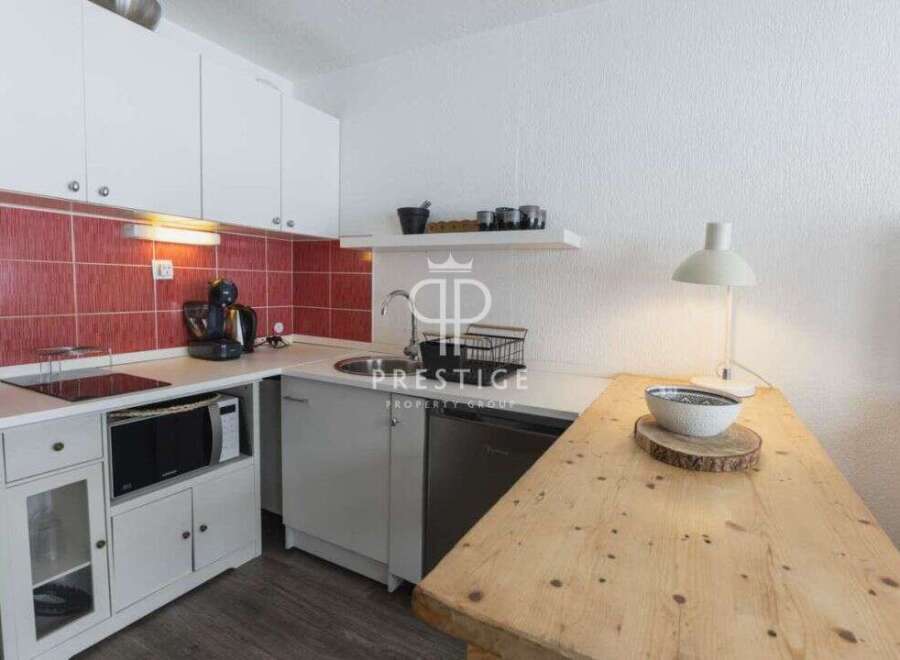 Discover this charming studio apartment featuring a well-equipped kitchenette, perfect for preparing meals.