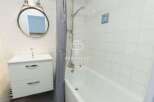 Discover a charming bathroom with a modern vanity and a relaxing bathtub.