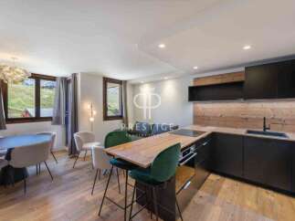 Discover a stunning property with a modern kitchen featuring sleek black cabinetry and a wooden countertop.