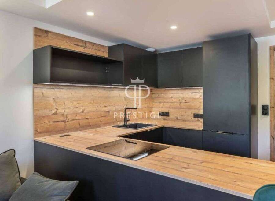 Modern kitchen design with sleek black cabinetry and a warm wooden countertop.