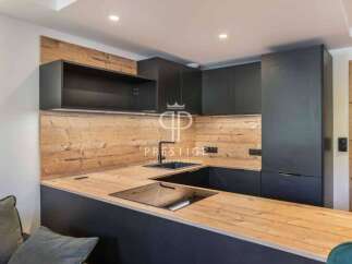 Modern kitchen design with sleek black cabinetry and a warm wooden countertop.