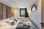 Experience luxury in this stunning property, featuring a cozy bedroom with a wooden accent wall.