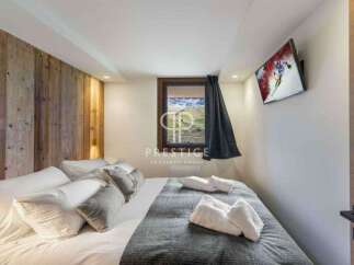 Experience luxury in this stunning property, featuring a cozy bedroom with a wooden accent wall.