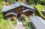Discover a stunning property with a charming wooden exterior and a beautifully designed roof.