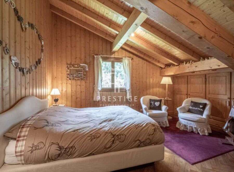 Cozy bedroom with wooden walls and ceiling, creating a warm and inviting atmosphere.