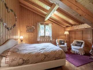 Cozy bedroom with wooden walls and ceiling, creating a warm and inviting atmosphere.