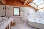 Discover a luxurious bathroom retreat with a stunning skylight and wooden accents.