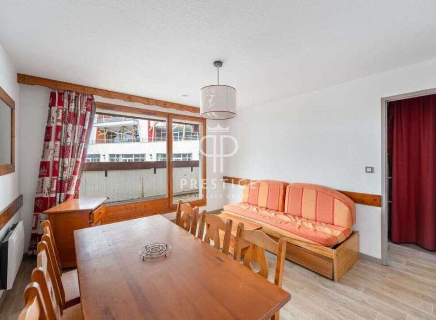 Discover a cozy living space with a charming wooden dining table and chairs, perfect for gatherings.