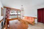 Discover a cozy living space with a charming wooden dining table and chairs, perfect for gatherings.