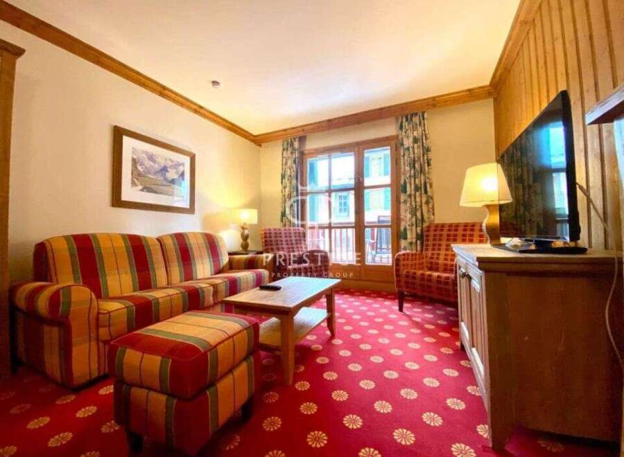 Cozy living room with a vibrant red floral carpet and striped sofa.