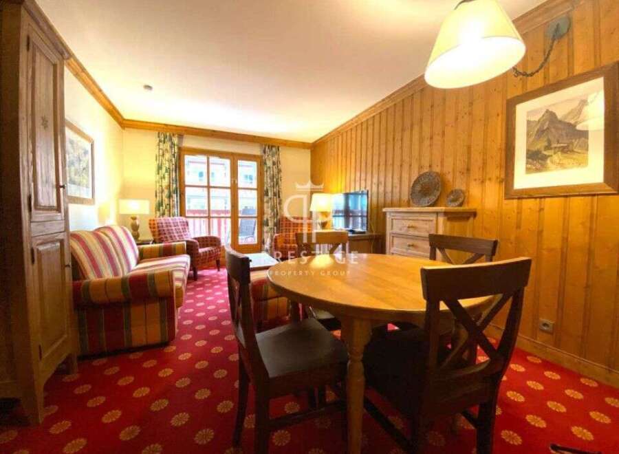 Cozy living space with wooden paneling and a charming round dining table.