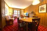 Cozy living space with wooden paneling and a charming round dining table.