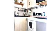 Cozy kitchen with a washing machine and a microwave.